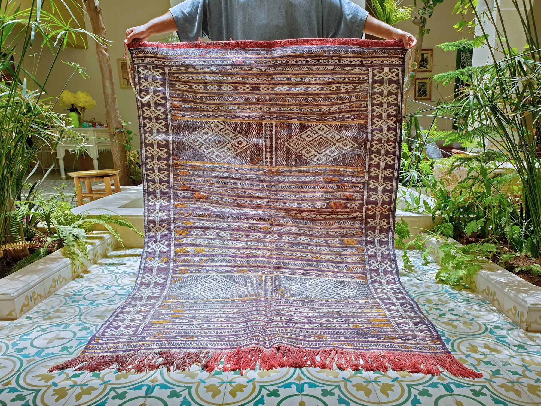 Handwoven Moroccan kilim displayed in a courtyard